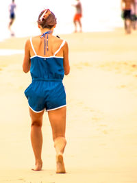 Rear view of woman walking on beach