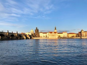 River by buildings against sky in city