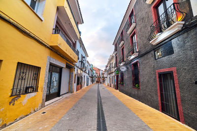 Empty alley amidst buildings in city