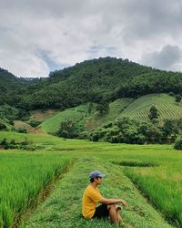 Man standing on field against sky