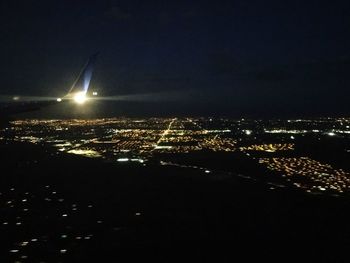 Illuminated cityscape against sky at night