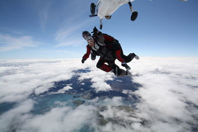 Low angle view of person paragliding against sky