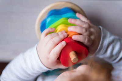 Close-up of hands holding multi colored baby