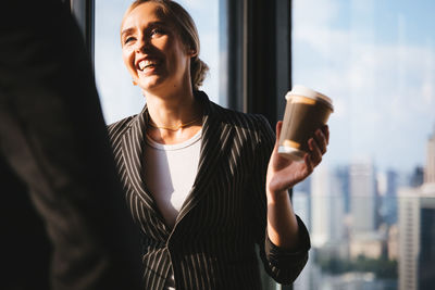 Young woman looking away while standing in city