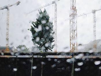 View through window wet glass onto construction site on rainy summer day