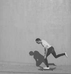 Man skateboarding against wall