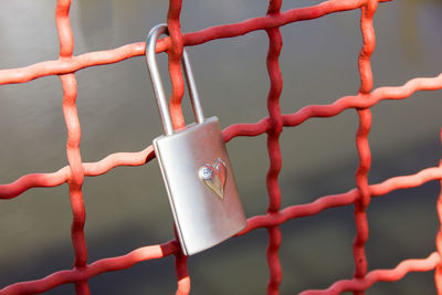 Close-up of love lock hanging on fence