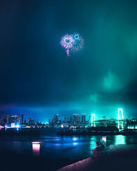 Firework display over illuminated city at night