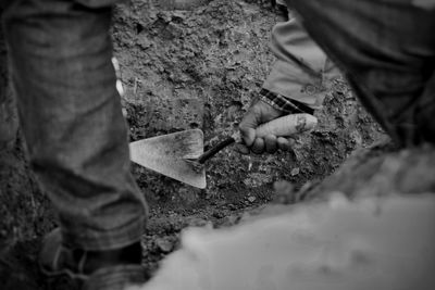 Low section of man working on rock