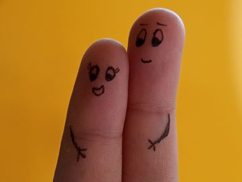 Close-up of human hand against yellow background