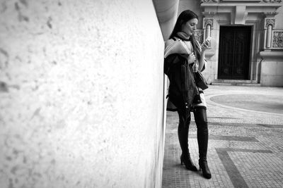 Full length of woman standing by railing