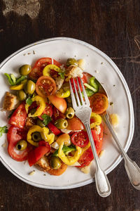 Isolated plate of fresh salad with tomato, olive, and sweet pepper. top view. copy space.