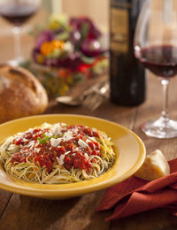 Close-up of pasta by wine on table