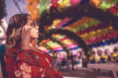 Close-up of young woman sitting in ornamental garden 