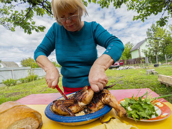 Full length of man preparing food on barbecue grill