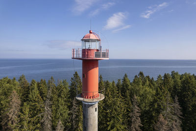 Lighthouse by sea against sky