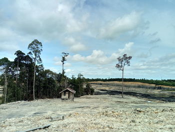 Abandoned house on field against sky