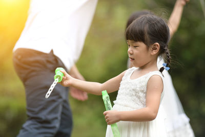 Cute girl holding white while standing outdoors