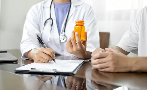 Midsection of doctor examining patient at clinic