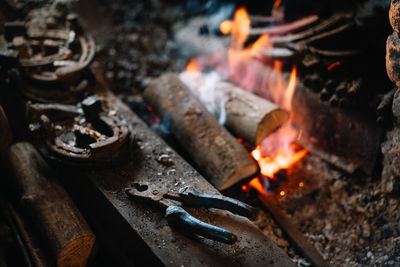 High angle view of blacksmith hand tool by bonfire
