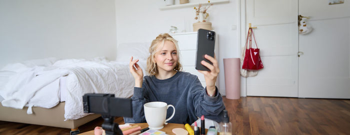 Portrait of young woman sitting at home