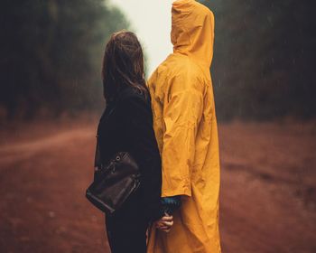 Rear view of friends standing outdoors