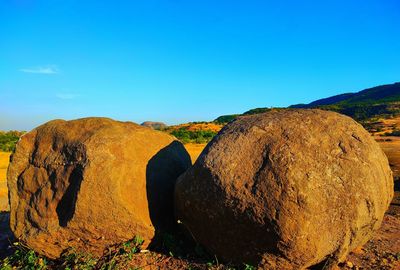 Panoramic view of rocks on land against blue sky