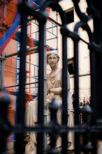 Classical statue among bars and scaffolding