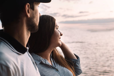 Happy pregnant family looking to the lake