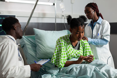 Doctors examining patient in clinic