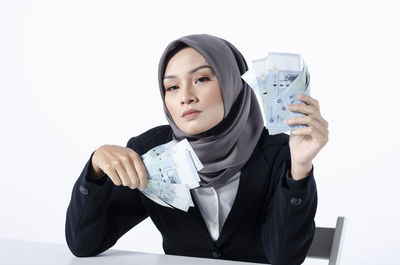 Portrait of beautiful young woman against white background