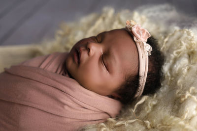 Portrait of newborn sleeping on bed 