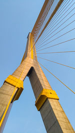 Low angle view of suspension bridge against clear blue sky