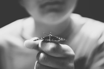 Close-up of cropped hand holding cigarette