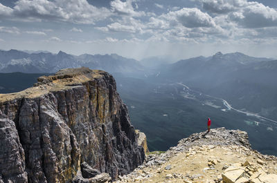 High angle view of man standing on cliff against mountains