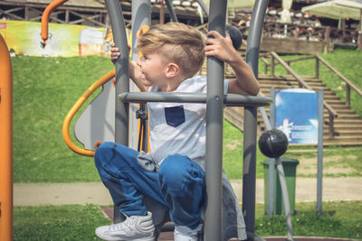 Boy playing on outdoor play equipment at playground