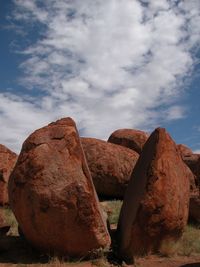 Rock formation against cloudy sky