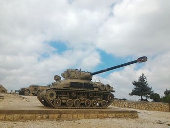Armored tank against cloudy sky