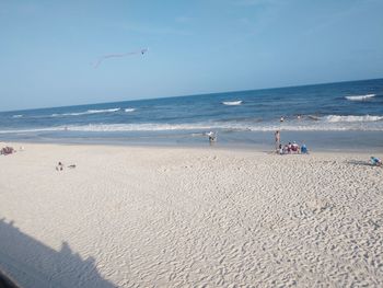 People on beach against sky