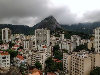 Aerial view of cityscape against cloudy sky