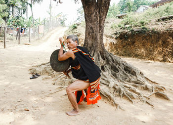 Side view of woman sitting on rock