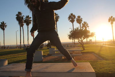 Man standing on bench in park