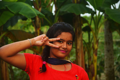 Portrait of smiling young woman with leaves outdoors