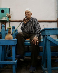 Full length of man sitting on seat