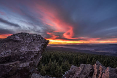 Scenic view of landscape against dramatic sky during sunset