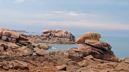 Rocks on sea shore against sky