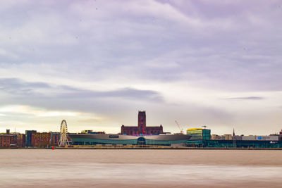 Buildings by sea against sky in city