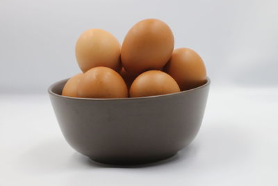 Close-up of eggs in bowl against white background