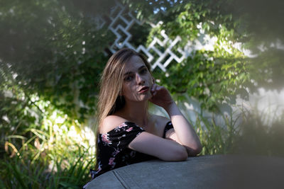 Portrait of young woman sitting outdoors