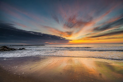 Scenic view of beach against sky during sunset